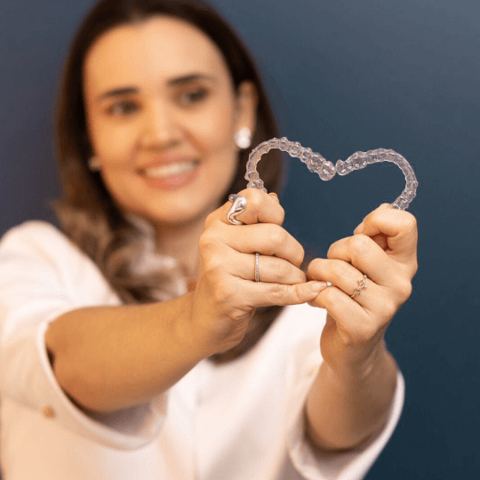 Dra Clara Vasconcelos segurando o produto Invisalign